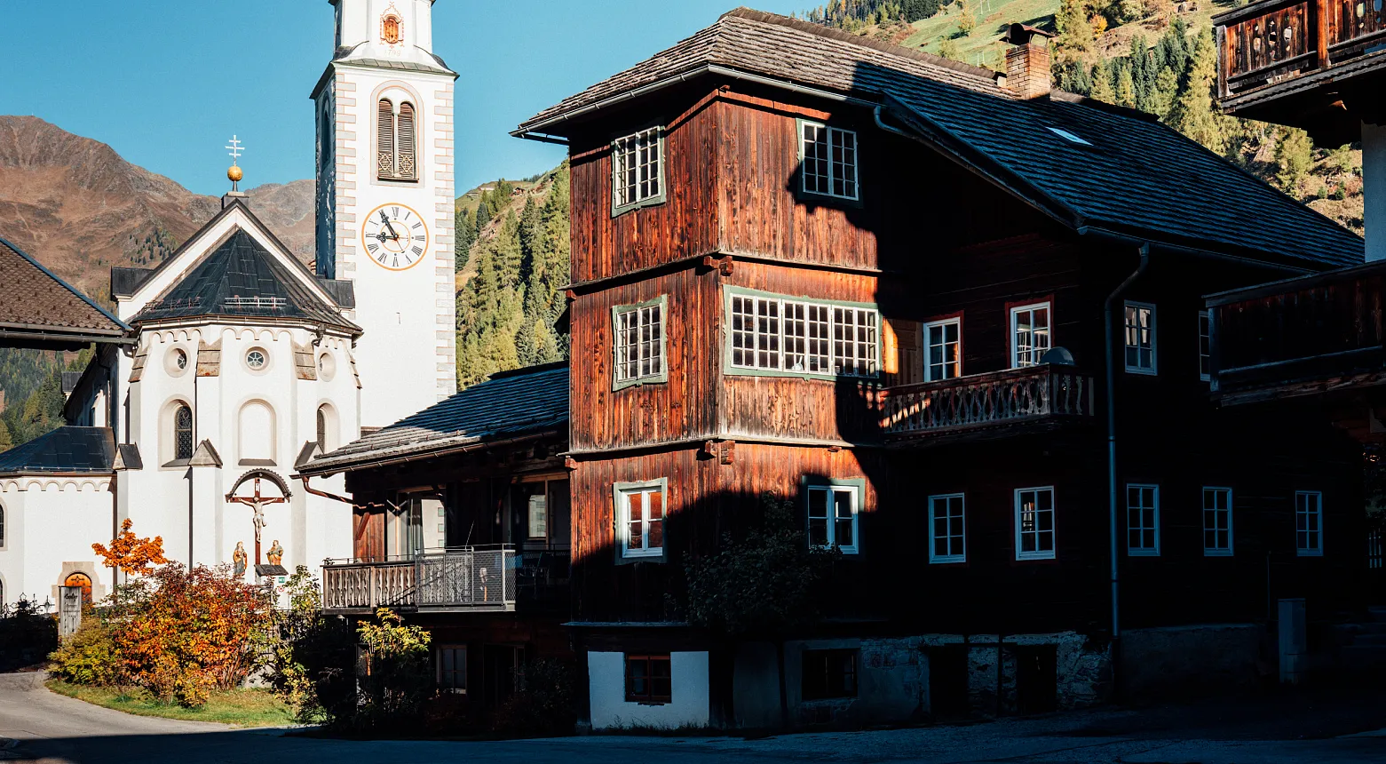 Grundriss einer Etage eines Gebäudes mit verschiedenen Räumen. Der Grundriss zeigt eine Küche, einen Essbereich mit einem großen Tisch, ein Wohnzimmer mit Möbeln, Treppen und eingebaute Regale. Es gibt auch Balkone oder Terrassenbereiche, die von innen zugänglich sind. Der Plan ist in einer Draufsicht dargestellt, die eine Übersicht der Raumaufteilung und Architekturdesigns bietet.